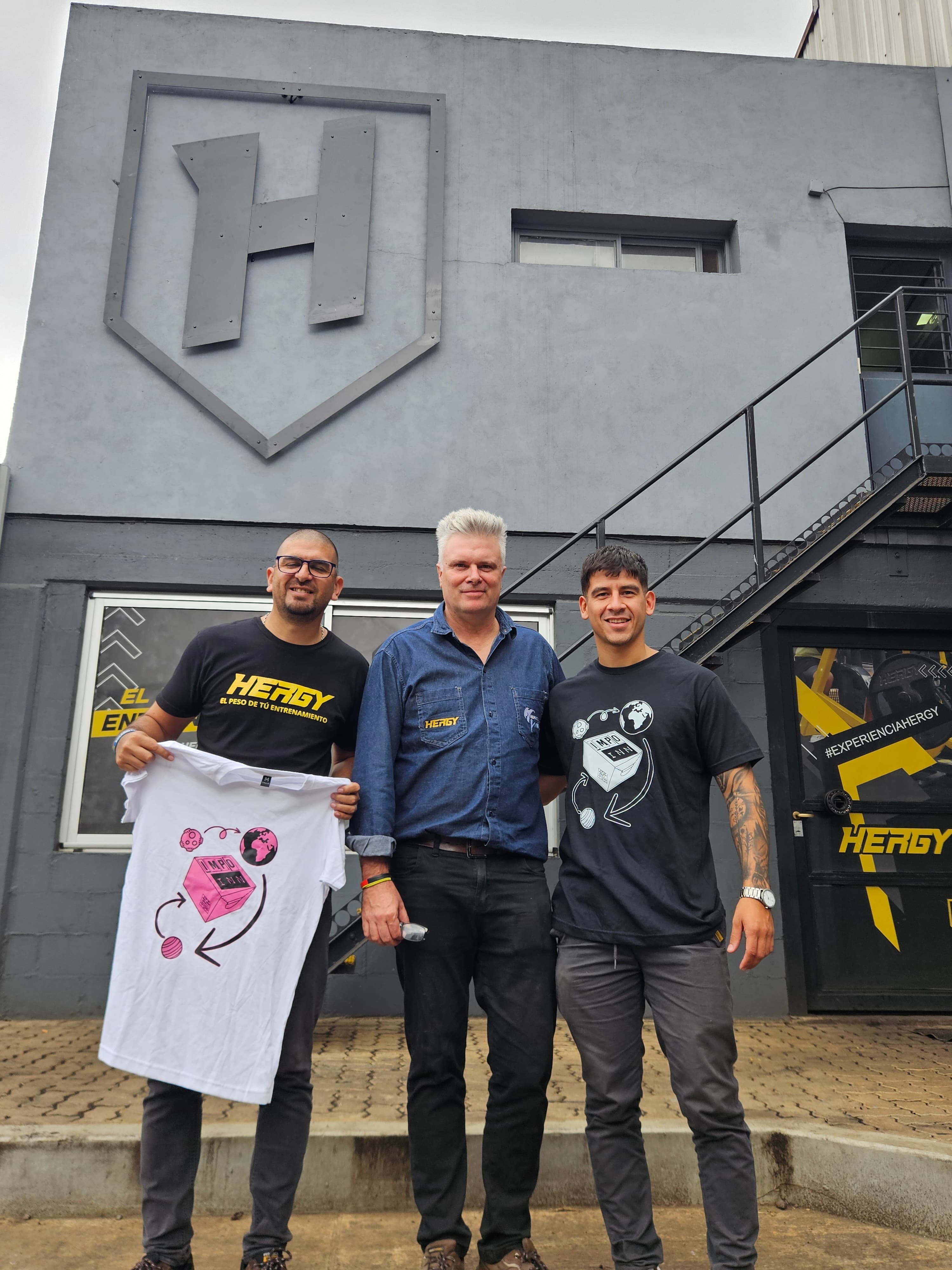 Equipo empresarial visitando fábrica Herzy con camiseta Impo INN